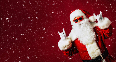 Close up portrait of a beautiful happy stylish Santa Claus is posing on a red background. Winter holidays and Merry Christmas