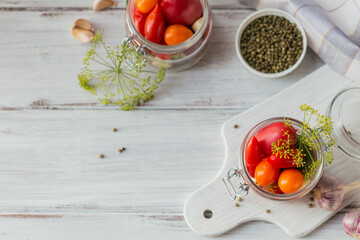 Top view of raw healthy food on white wooden table mockup. Delicious, organic, tasty and ripe tomatoes with seasonings and garlic in glass jar background with copyspace for text.