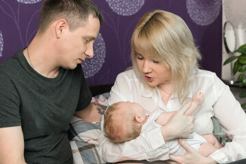 Young parents with a small child. Mom talking to the baby. Happiness to be parents