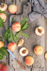 Several ripe juicy peaches on a wooden surface. Peach fruits on the wooden board. Green living. Organic food.