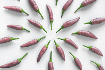 Pink metalic color chilly peppers abstract top view pattern on a white background. Flat lay.