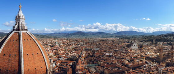 Detail of the dome of Florence cathedral of Santa Maria del Fiore (Saint Mary of the Flower), with the full view of the city, the hills of tuscany and the blue sky in background