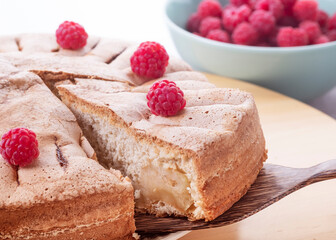 Slices of homemade raspberry pie and bowl of fresh berries.