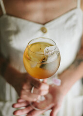 woman in white dress drinking a refreshing cold tea with lemon
