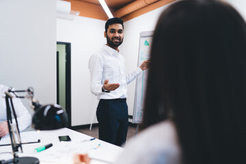 Ethnic man discussing project with coworker in office