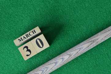 March 30, Number cube With a snooker stick on a green background, snooker table.	
