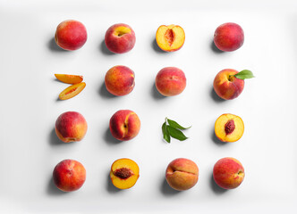Fresh ripe peaches and green leaves on white background, flat lay