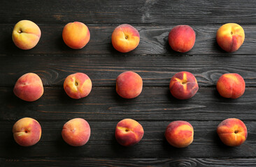 Fototapeta na wymiar Fresh sweet peaches on black wooden table, flat lay