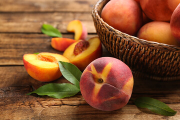 Fototapeta na wymiar Fresh sweet peaches in wicker basket on wooden table, closeup