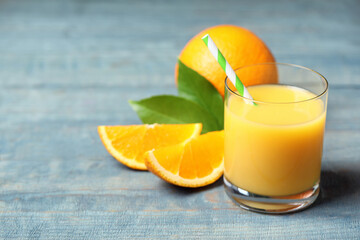 Glass of orange juice and fresh fruits on wooden table, closeup. Space for text