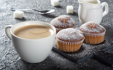 Coffee muffins on a wooden Board. Sweet muffins with berry filling on the table.Muffins sprinkled with powdered sugar.