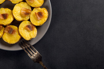 Baked potatoes with lard, a strata-fast delicious lunch, in a plate on a stone table. Copy space.