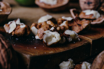 Cracked walnut kernels. Close-up on rustic old wooden table. Macro shot.