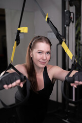 portrait of a girl exercising in a gym and squatting in a smitt machine.