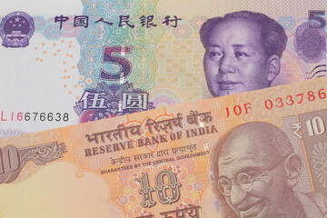 A macro image of a orange ten rupee bill from India paired up with a purple, blue and white five yuan bank note from China.  Shot close up in macro.