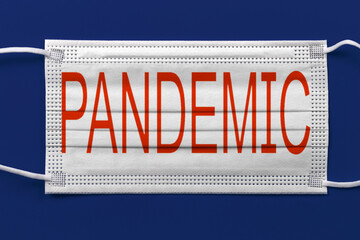 medical face mask on a blue background, with the inscription pandemic