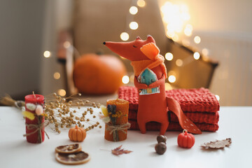 Autumn cozy still life with toy, sweaters and leaves. sweater-weather. Creative autumn backdrop concept. Flat lay, hygge style