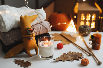Autumn cozy still life with toy, sweaters and leaves. sweater-weather. Creative autumn backdrop concept. Flat lay, hygge style