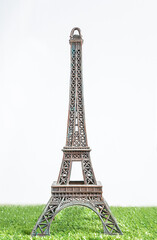 The Eiffel tower on green grass and white background. Travel destinations concept