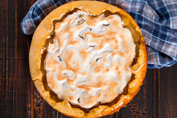 Pear pie with cream, homemade pastries on wooden table. Copy space.