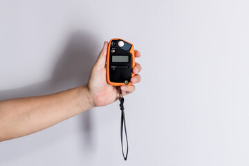 Hand holding light exposure meter, a photograph device for measuring illumination on white background. Hand held light meter isolated in studio lights.