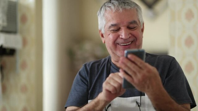 Smiling happy senior using cellphone device