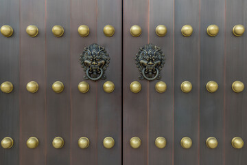 The door and knockers of Chinese temple. Ancient Asian door from temple. Chinese door. Oriental design of door of palace hall in Forbidden City. 