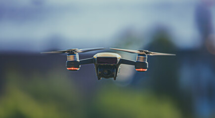 Drohne in Zeitlupe steht mitten im Flug in der Luft bei verschwommenem Hintergrund im Sommer in freier Natur. Nahaufnahme einer Drohne mit Bokeh Effekt. © Jakob