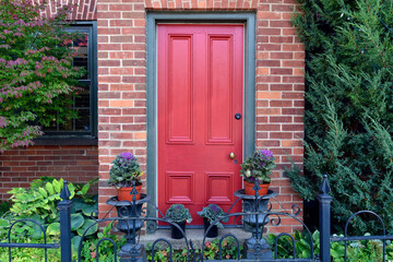 Fototapeta na wymiar Facade with red door and ornamental kale in autumn.
