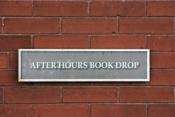 After hours book drop sign at a public library.