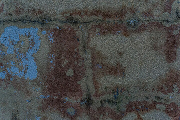  Old paint peeling from wall baring the cemented brick and rust. Grungy texture background