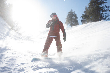 winter, leisure, sport and people concept - Active snowboarder jumping in mountains on a sunny day. Snowboarding closeup. Sheregesh ski resort