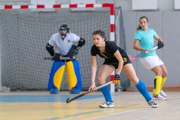 Young female hockey player in defence at the match - Powered by Adobe