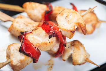 Traditional, oriental and Asian kebabs on a wooden skewer of grilled chicken pieces boiled rice as a garnish.