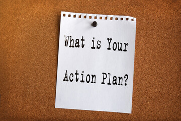 Paper note written with WHAT IS YOUR ACTION PLAN inscription on cork board