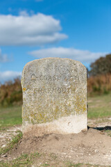 Close up of a signpost  made out of stone pointing towards Charmouth in Dorset