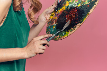 Woman artist green dress easel eat drawing art pink background