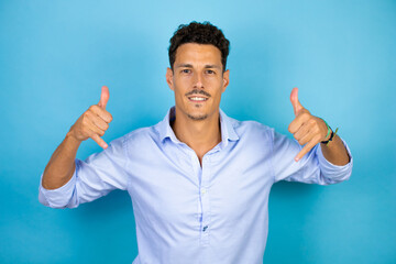 Young handsome man wearing blue shirt over isolated blue background shouting with crazy expression...