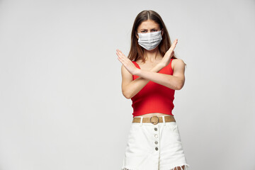 Woman in protective mask against coronavirus posing in studio.