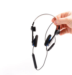 man's hand holds classic black headphones with bluetooth headset. isolated background. music...