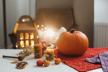 Cozy autumn hygge composition. still life with candle, leaves, pumpkin, textiles. Halloween, Thanksgiving. Flat lay, top view