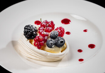 Delicious cake with berries: red currants, blueberries, blackberries. Cream and beautiful shape. Dessert in the restaurant.