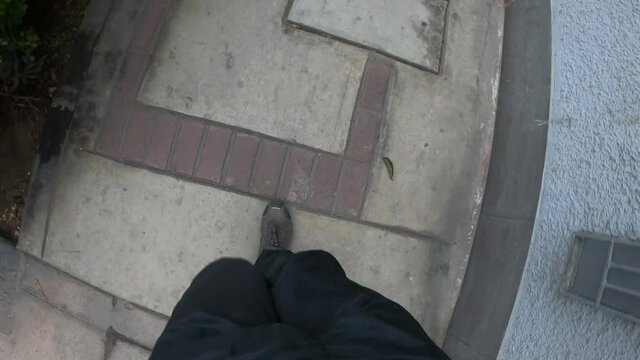 point of view of the legs of a man finishing running and slowing down