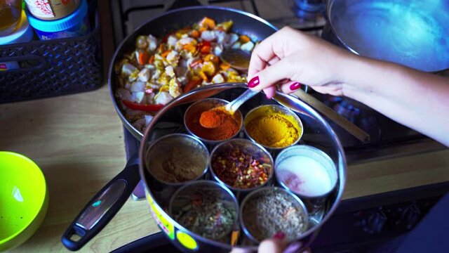 Spicy Indian cuisine preparation, Masala ( spices ) are spread even to a cooking pan with vegetables and chicken which is being made Indian style