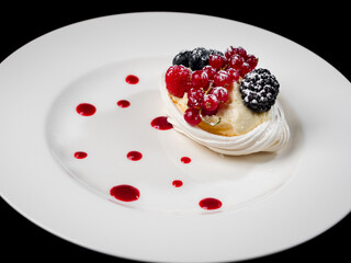 Delicious cake with berries: red currants, blueberries, blackberries. Cream and beautiful shape. Dessert in the restaurant.