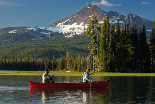 Couple canoeing on Sparks Lake under Broken Top mountain Oregon