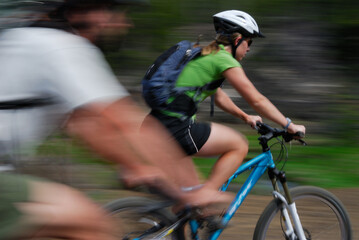 Fototapeta na wymiar female mountain bike rider with blured male rider