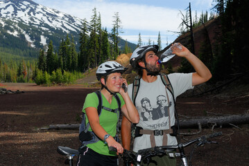 Naklejka premium Mountain bike riders drinking and calling home from Mount Bachelor