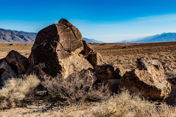 rock formations in desert valley with distant Sierra Nevada mountains of California