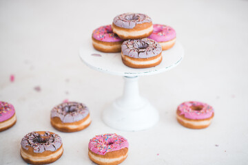 Glazed donuts on white stand over white background close up. Birthday party.